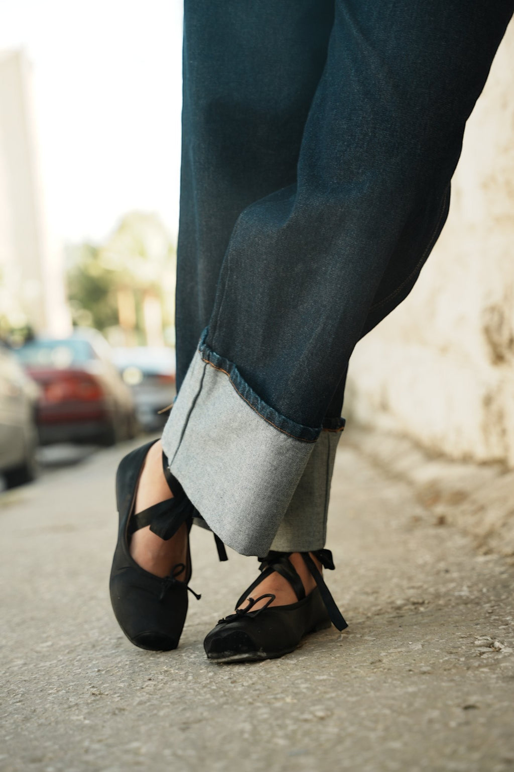 shorouqmazrawi indigo wide-leg denim pants with a prominent 15cm cuffed hem, styled with black ballet flats
